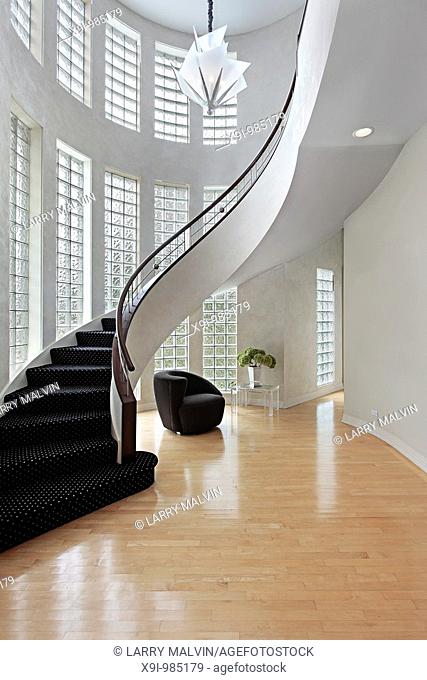 Foyer in upscale suburban home with curved staircase