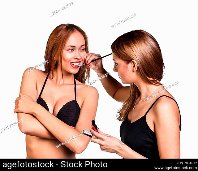 Make-up artist applying lipstick with a brush on model#39;s lips