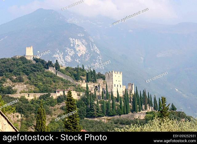 view of medieval castle above little historical town , shot from west in bright fall light at Arco, Trento, Italy