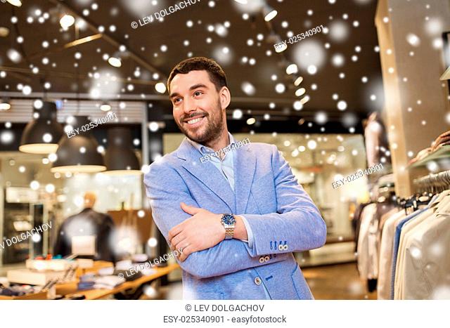 sale, shopping, fashion, style and people concept - happy young man in jacket at clothing store over snow