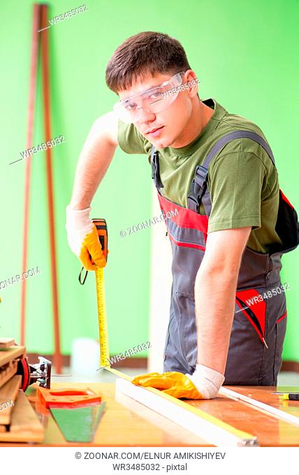 Young man carpenter working in workshop