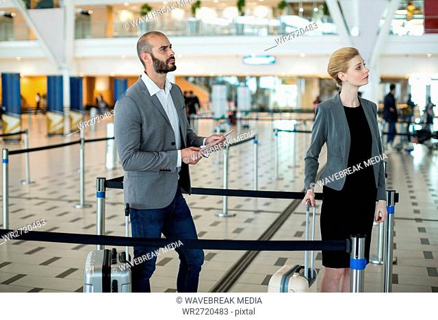 Businesspeople waiting in queue at the check-in counter with luggage
