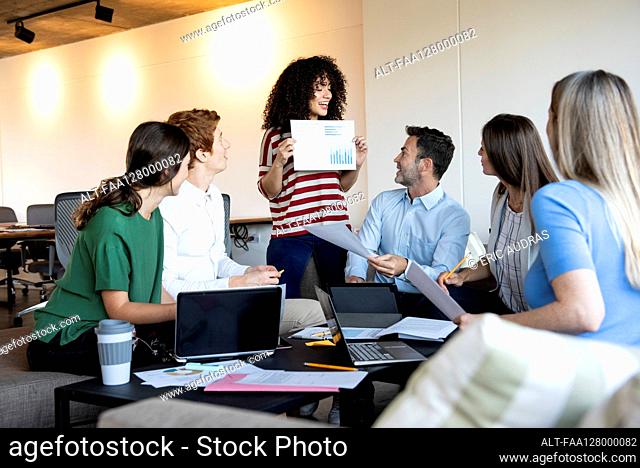 Businesswoman showing a document to her colleagues