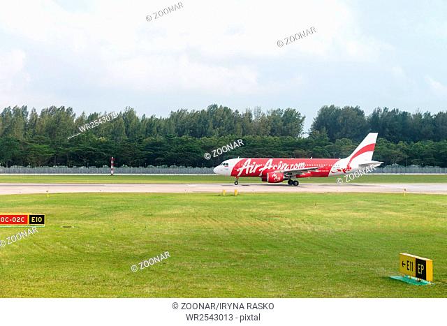 SINGAPORE - 02 JAN 2014: Airplane of AirAsia low-cost airline taxis around Changi airport to runaway