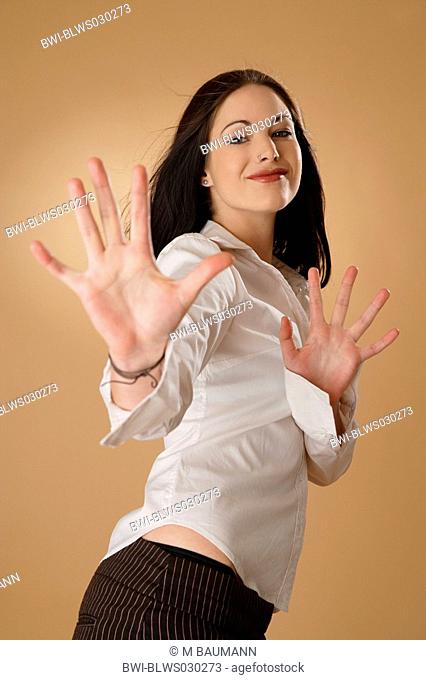 portrait of a young darkhaired woman in white blouse, stretching her arms