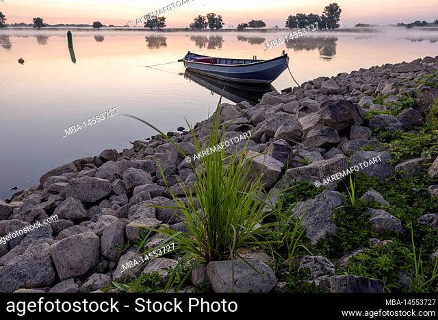 View of the Elbe in the early morning and a boat on the shore