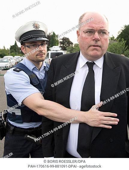 Walter Kohl (R), son of former German Chancellor Helmut Kohl, is temporarily held up by a member of the German police near the residence of his father after the...