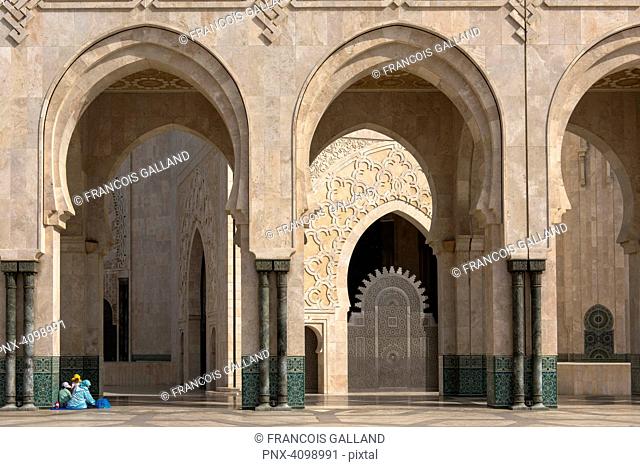 Famille installee pour une pause dominicale au piede la colonade du peristyle de la Mosquee Hassan II. Casablanca, Maroc