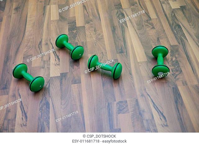 green dumbbells on patquet floor