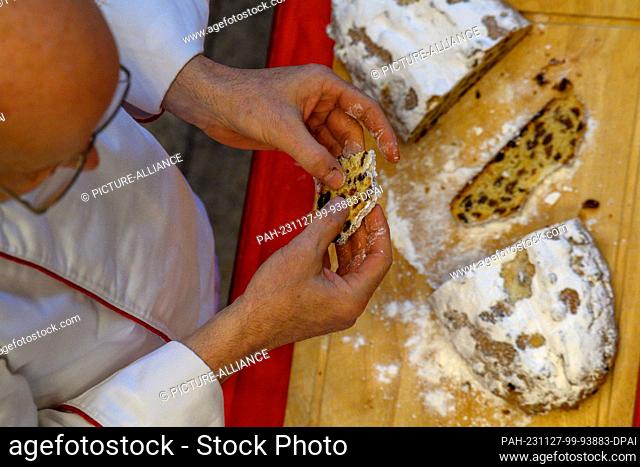 27 November 2023, Saxony-Anhalt, Magdeburg: Siegfried Brenneis from the German Bread Institute checks the consistency of a stollen during the public stollen...
