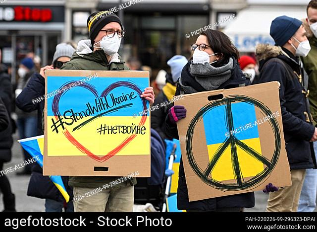 26 February 2022, Bavaria, Munich: Protesters hold placards reading ""#StandWithUkraine"" during a demonstration at Odeonsplatz against Russia's attack on...