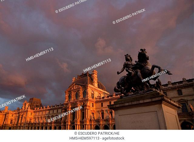 France, Paris, the Equestrian statue of Louis XIV and the facades of the Cour Napoleon of the Louvre Museum