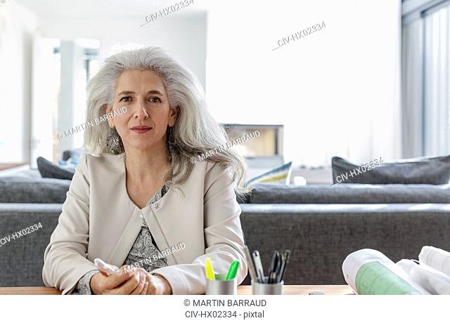 Portrait confident female architect in home office