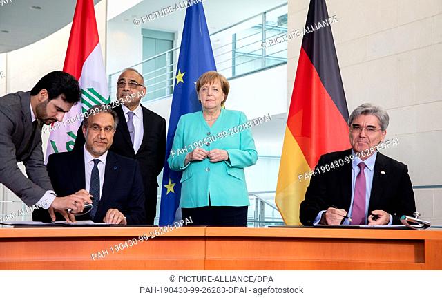 30 April 2019, Berlin: Federal Chancellor Angela Merkel (CDU) and Adel Abdel Mahdi, Prime Minister of Iraq, observe the signing of the contract to implement the...