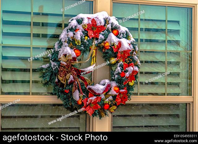 Christmas wreath on the glass window of a home. Colorful Christmas wreath hanging on the glass window of a home in Daybreak, Utah