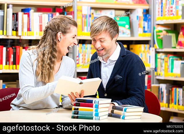 Couple, woman and man, in library reading books