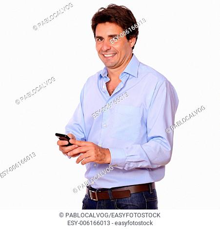 Portrait of a stylish hispanic man texting on cellphone while standing on white background