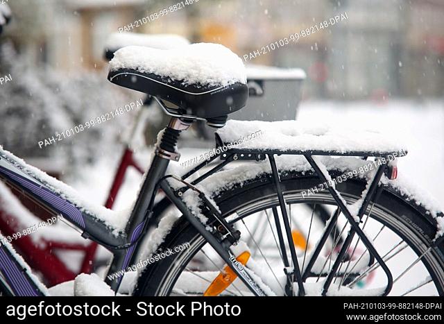 03 January 2021, Saxony-Anhalt, Wernigerode: Parked bikes are covered in snow. Snow fell across large areas of the country on Sunday