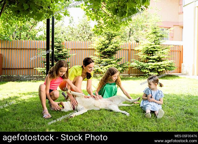 Mother and daughters with dog at back yard