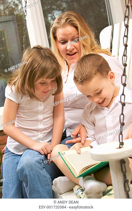 Young Boy Reads to His Mother and Sister