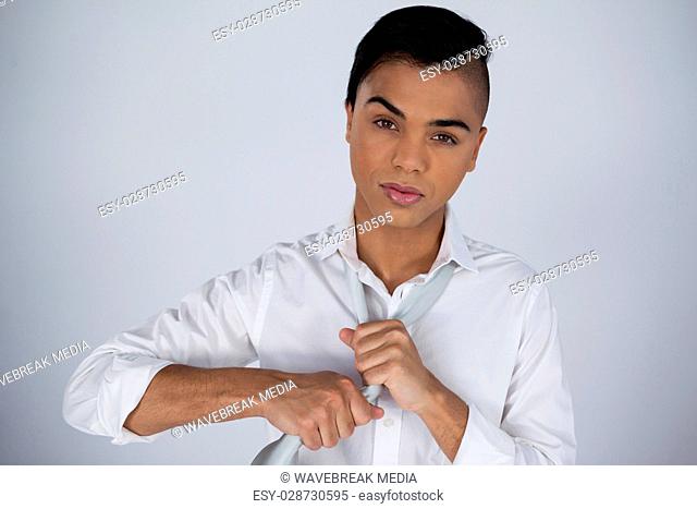 Portrait of transgender woman adjusting tie