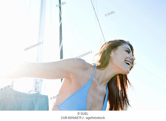 Young brunette woman on yacht, laughing