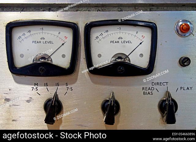 a close up of two old decibel meters on an old vintage reel to reel tape recorder with control knobs and switches
