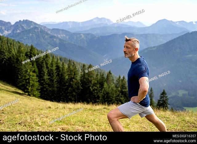 Man with hand on hip stretching while exercising