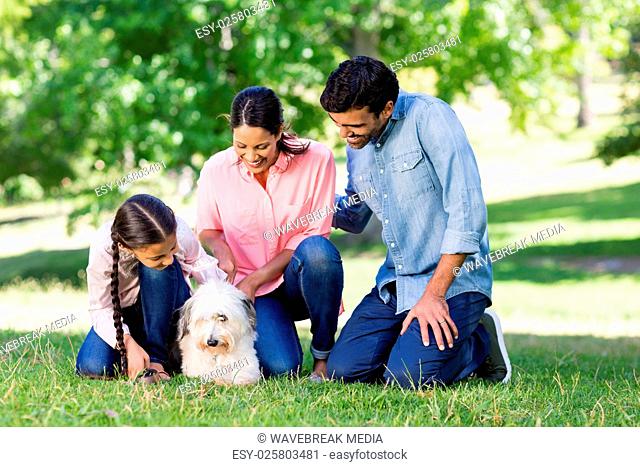 Family enjoying together with their pet dog in park
