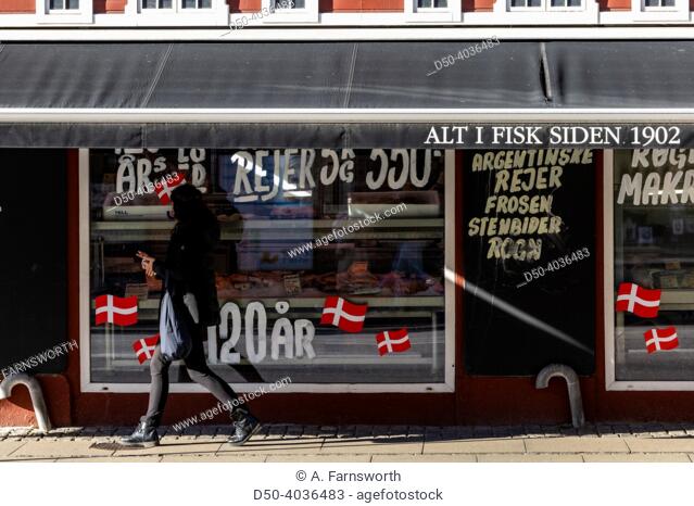 Copenhagen, Denmark Pedestrians walking the Amager district past a fish store