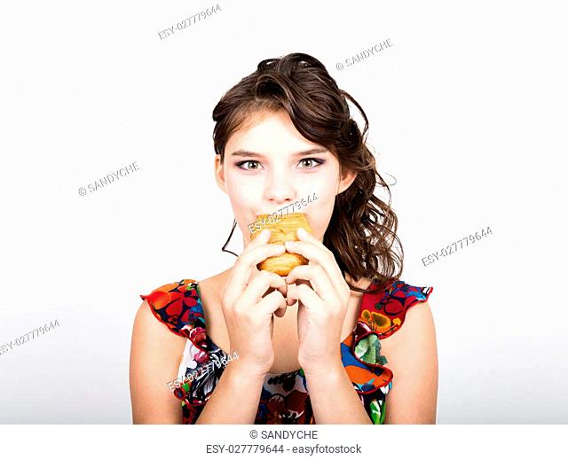 Young smile girl holding and biting bread roll