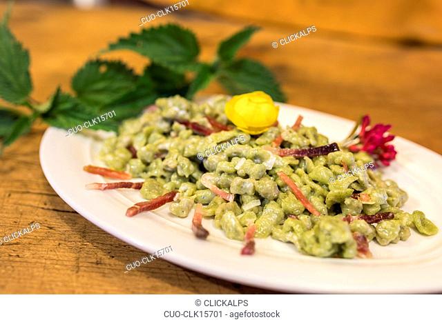 Plate of gnocchi with cheese and cured meat, San Romerio Alp, Brusio, Canton of Graubünden, Poschiavo valley, Switzerland, Europe