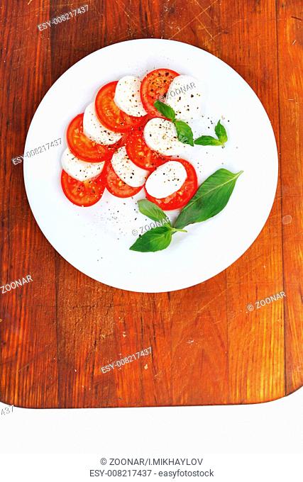 Mozzarella cheese tomato and basil on a plate