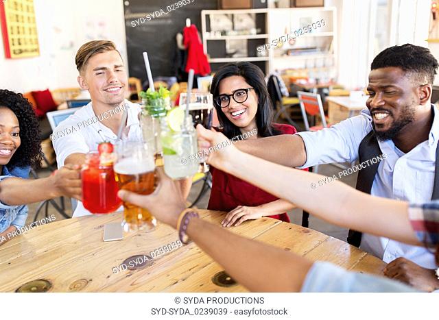 friends clinking glasses with drinks at restaurant
