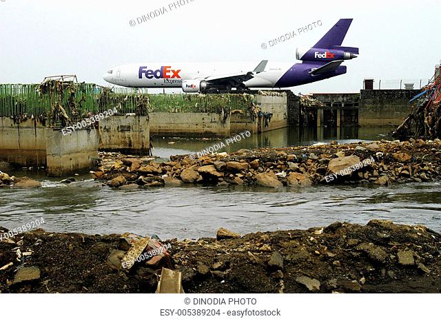 Commercial plane on runway ready for take off at Sahar airport or Chhatrapati Shivaji International airport surroundings by drainage in Bombay Mumbai ;...