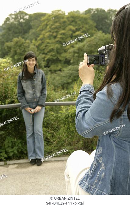 Woman is filming an Asian woman on a bridge, selective focus