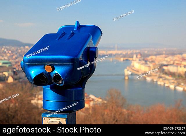 Blue binoculars and defocused panorama view of the famous Hungarian Parliament across the river Danube, Budapest