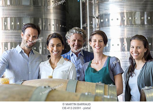 Portrait confident winery employees in cellar