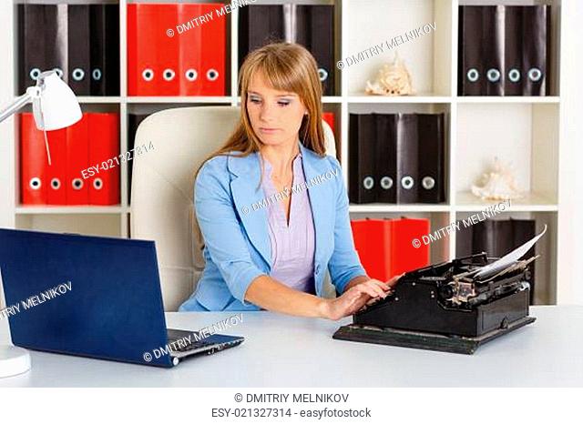Young woman with notebook and typewriter