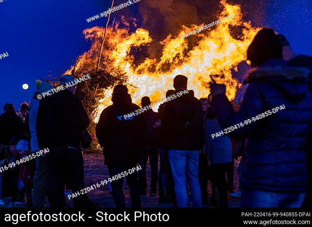 16 April 2022, Brandenburg, Cottbus: Visitors look at the Branitz Easter fire. The comrades of the volunteer fire department of the Branitz district of Cottbus...