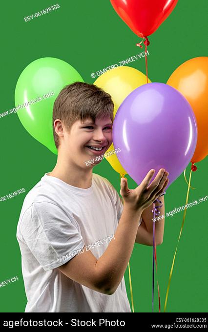 Bday. Young boy with balloons looking happy and excited