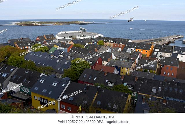 14 May 2019, Schleswig-Holstein, Helgoland: View of houses and the harbour of the North Sea island Helgoland. Photo: Carsten Rehder/dpa