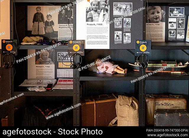 16 April 2020, Saxony, Pirna: In a showcase are photos, toys, clothes and suitcases of children, which will be the subject of the forthcoming exhibition 75...