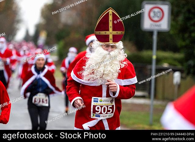 10 December 2023, Brandenburg, Michendorf: A participant runs through Michendorf in costume at the St. Nicholas Run. Costumed runners met for the fifteenth time...