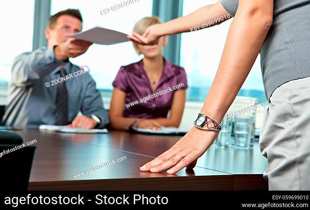 Close up of female hand resting on the table during business meeting. Focus placed on the hand
