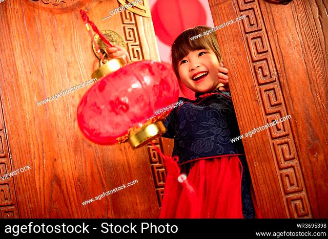 Beautiful little girl hand red lanterns to celebrate the New Year
