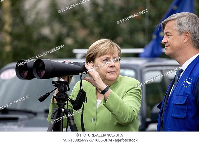 24 August 2018, Georgia, Odzisi: Federal Chancellor Angela Merkel (CDU) observes the administrative border line to Abkhazia and South Ossetia through binoculars...
