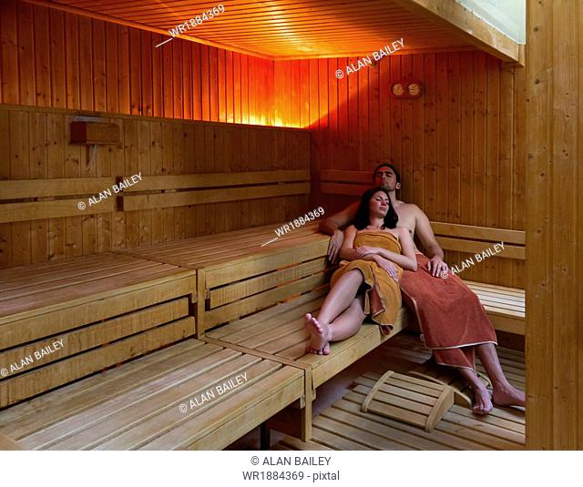 Italy, Tuscany, Young couple relaxing in sauna