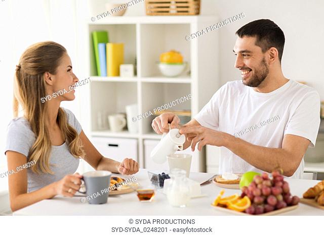 happy couple having breakfast at home