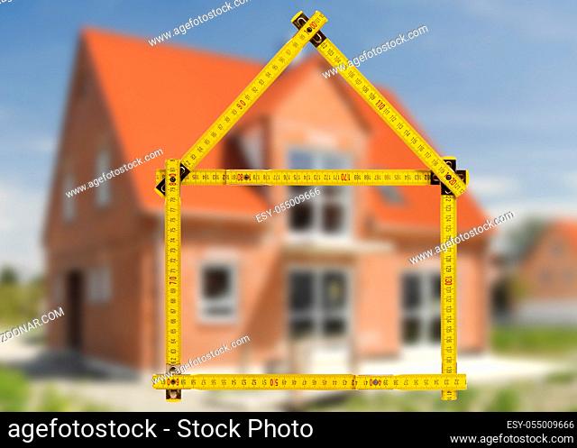 yardstick folded in form of an house in hand of an agent